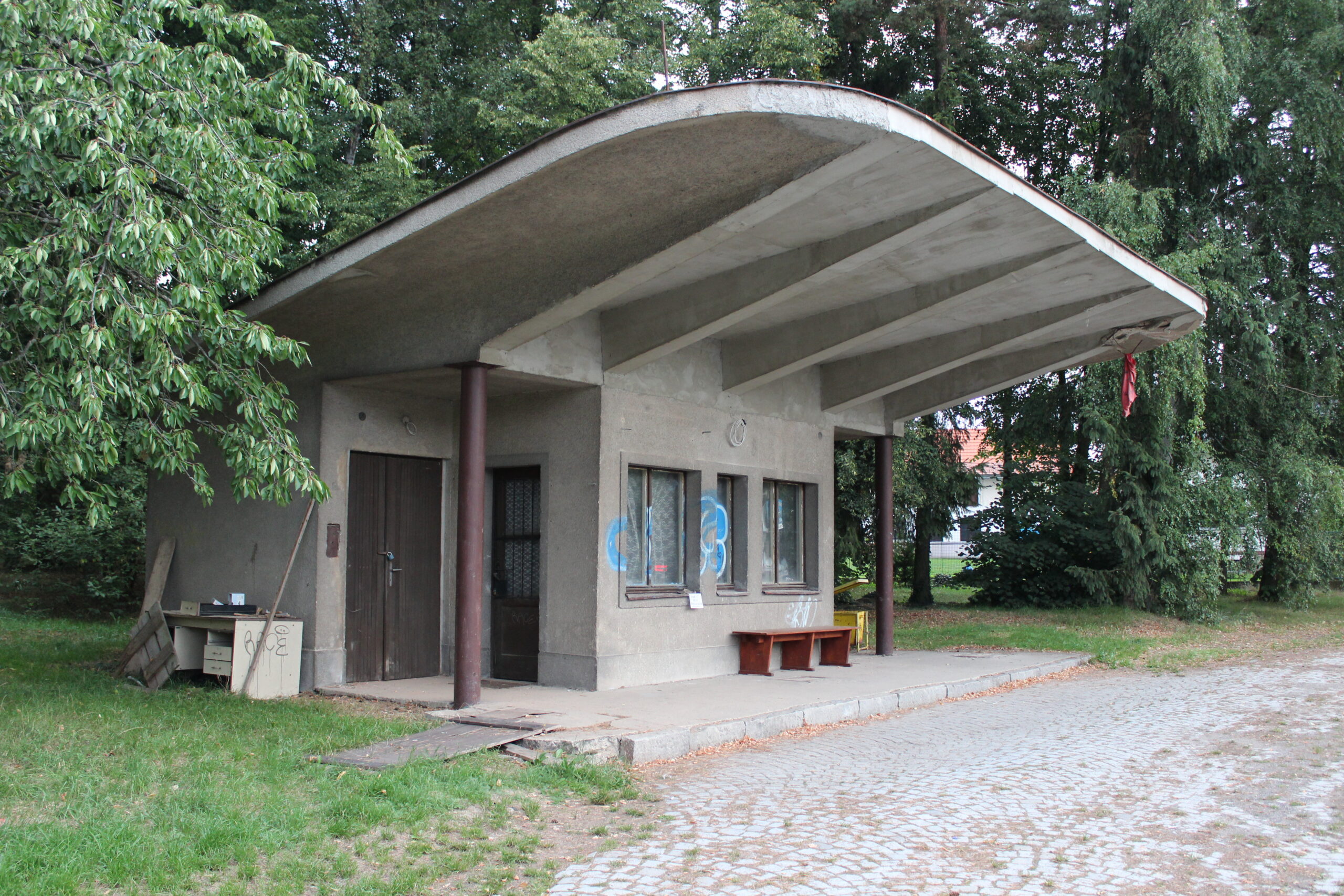 Historická silniční čerpací stanice z dob socialismu s betonovým přístřeškem u Milína