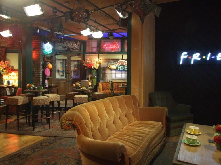 Původní studiová dekorace kavárny Central Perk s pultem a oranžovou pohovkou