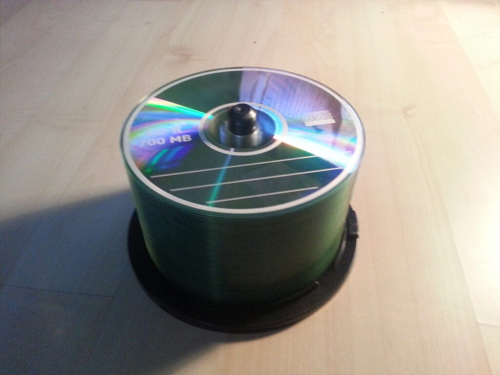 Stoh zapsaných kompaktních disků CD-R položených na stole