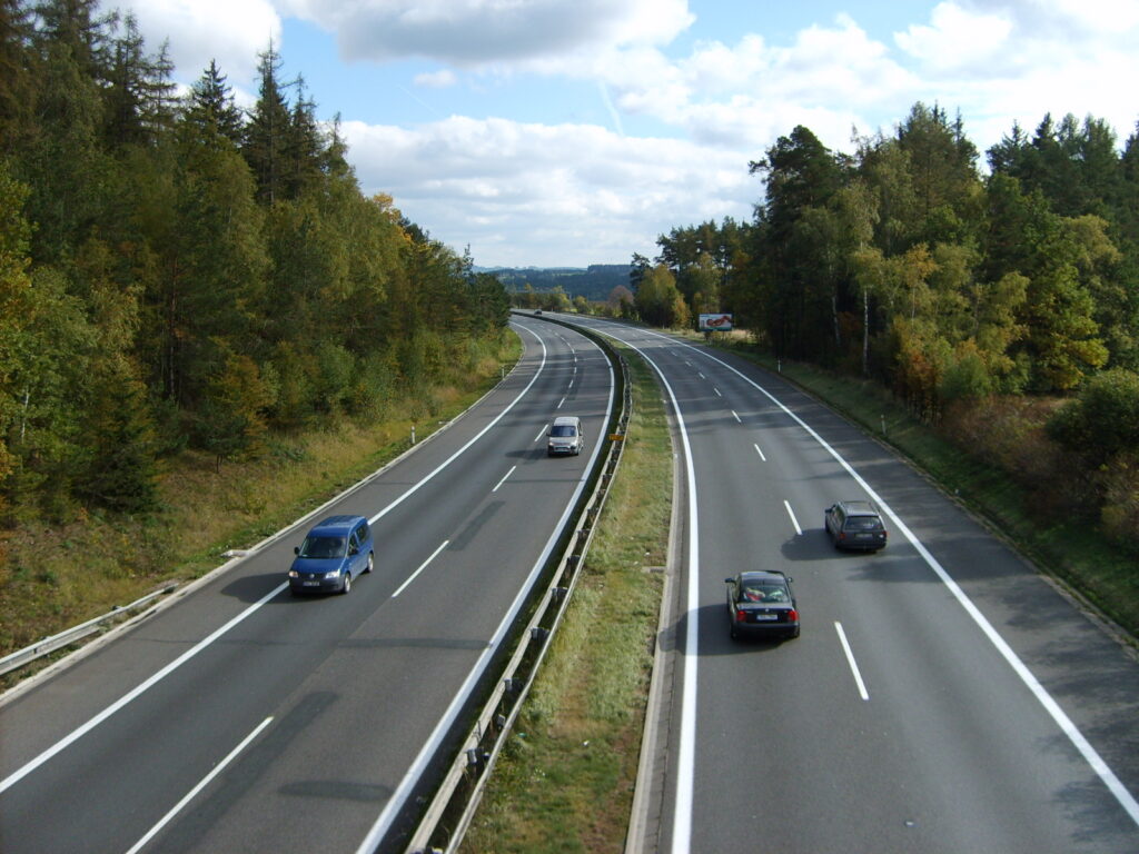Dálnice D1 s betonovým povrchem a svodidly vedoucí zvlněnou krajinou