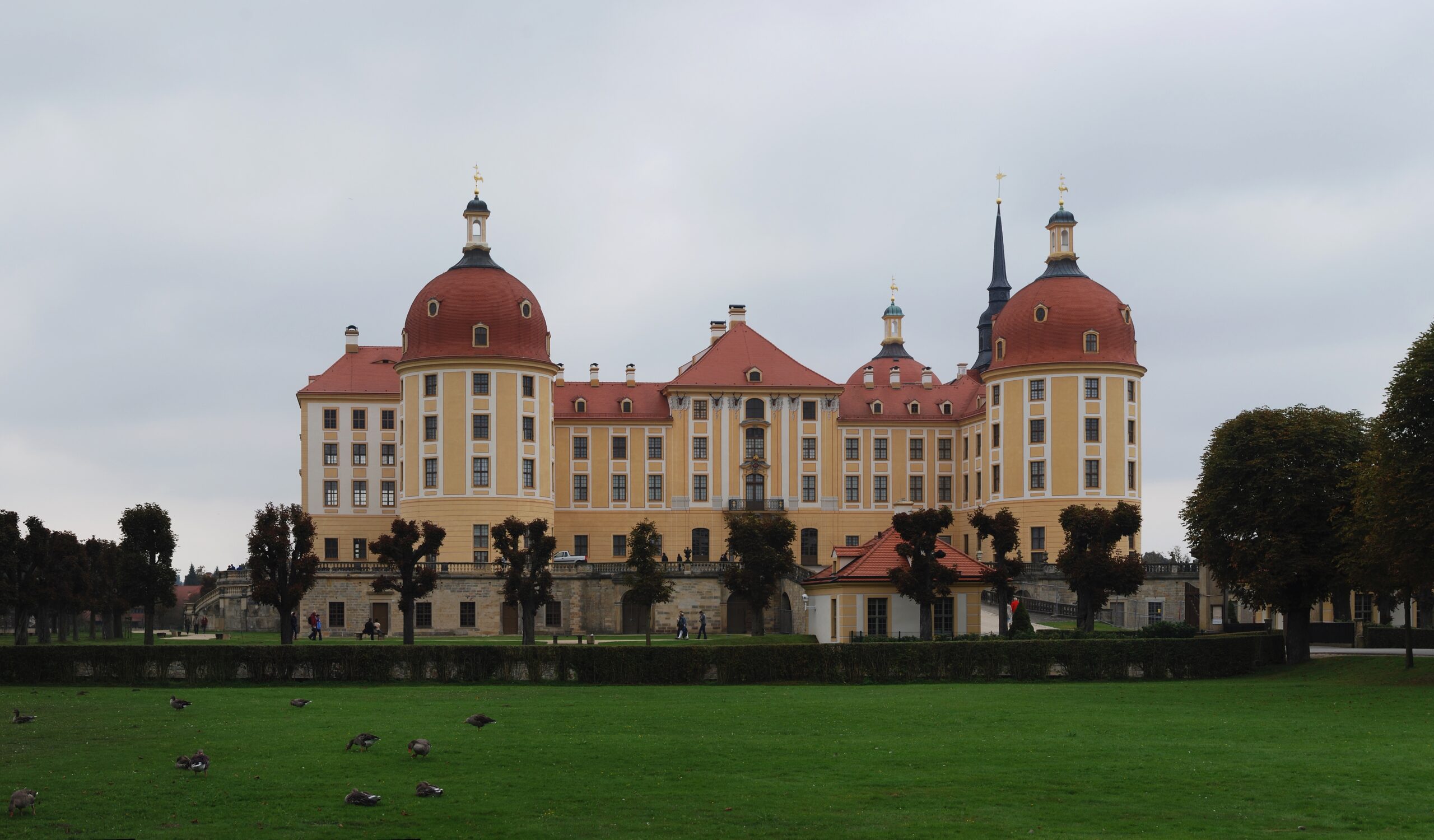 Pohled na barokní zámek Moritzburg obklopený vodní plochou, kde se natáčely venkovní scény královského bálu.