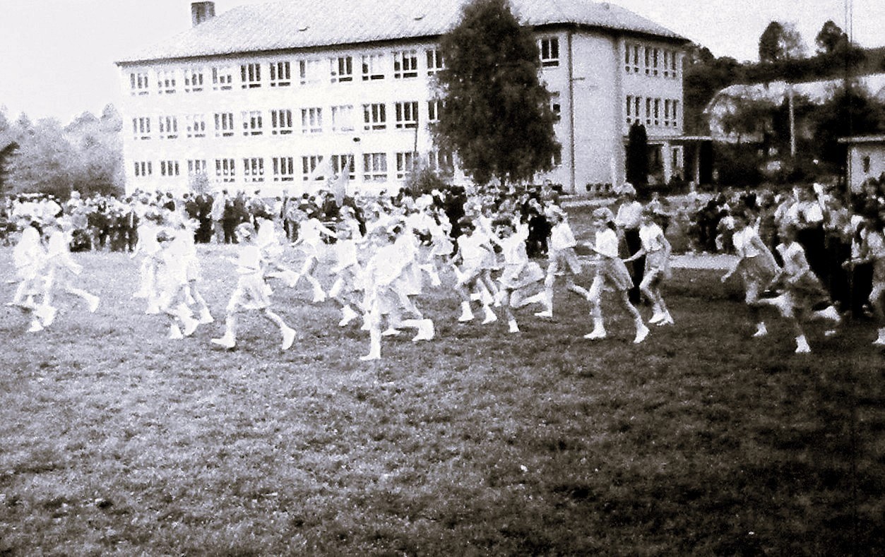 Skupina žáků základní školy při hromadném cvičení na venkovním hřišti během spartakiádního vystoupení v roce 1985.