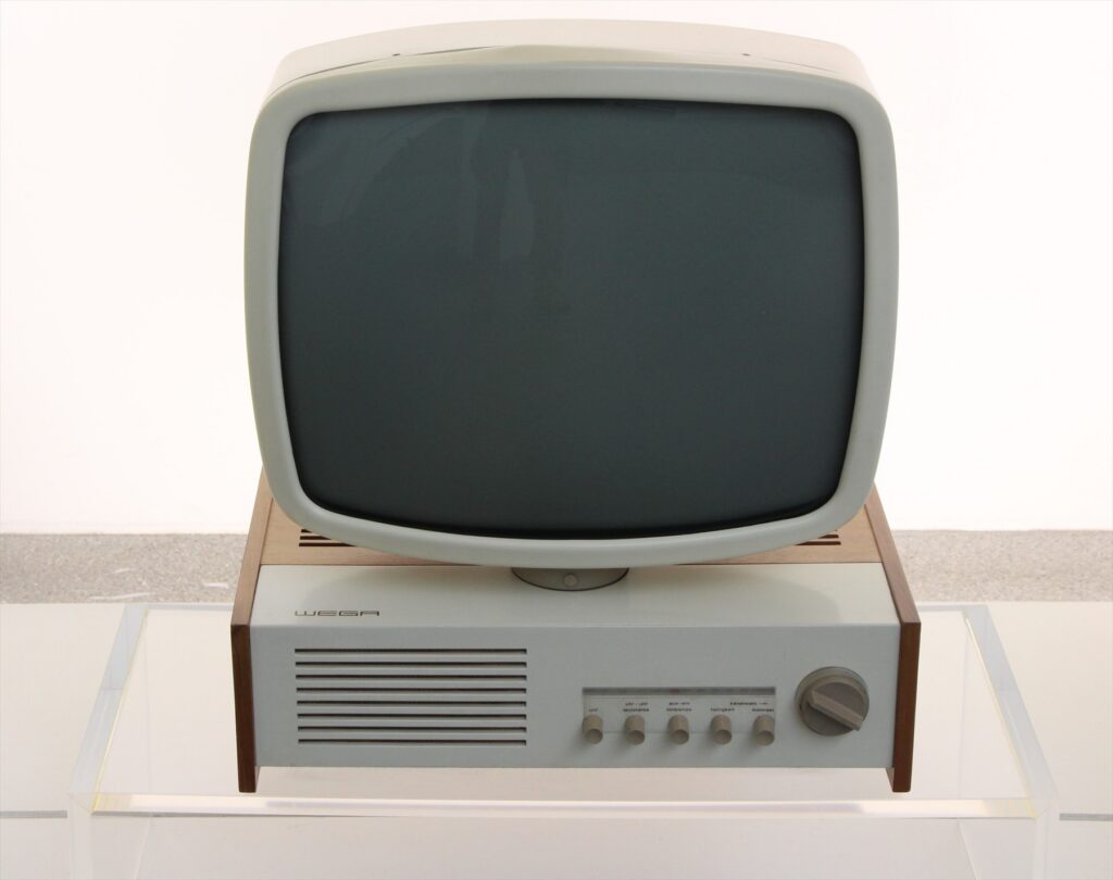 Televizor Wega s velkou zaoblenou obrazovkou nad skříní s reproduktorem a ovládacími knoflíky