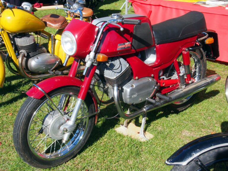 Červená Jawa 250 Bizon z levého předního boku na travnaté ploše.