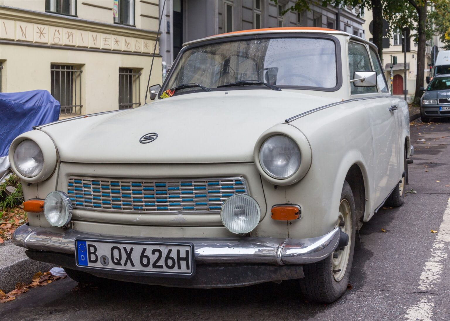 Světlý Trabant 601 de Luxe zaparkovaný u chodníku v Berlíně.