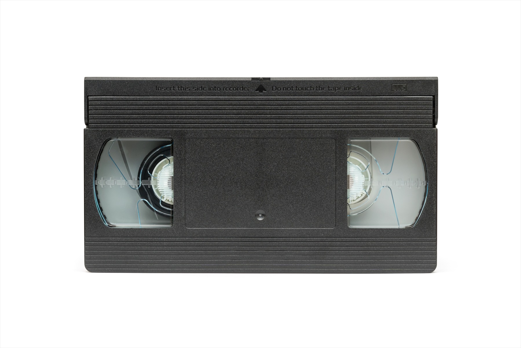 Čelní pohled na černou videokazetu formátu VHS s průhledovými okénky na cívky magnetického pásku.