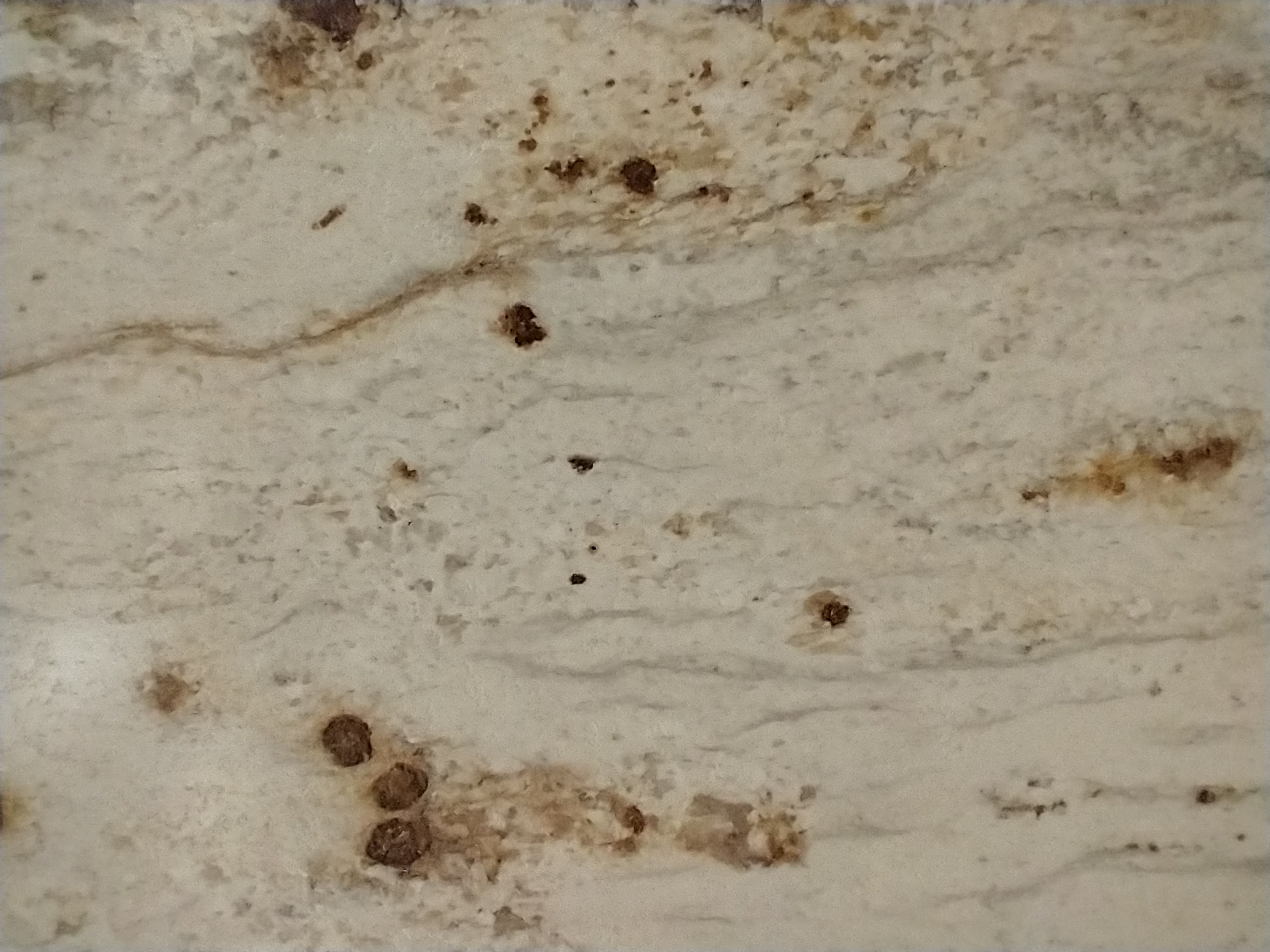 Detail světlého laminátového povrchu s hnědým dekorem připomínajícím kámen