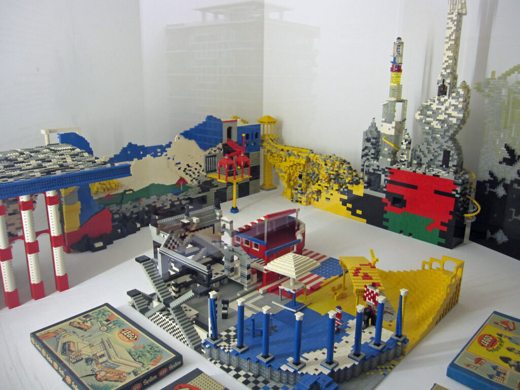 Muzejní vitrína v Německém muzeu v Mnichově s historickými krabicemi Lego ze začátku éry systému z 50. let.