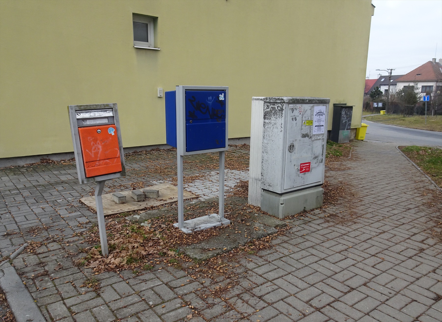 Řada plechových poštovních schránek na zdi činžovního domu