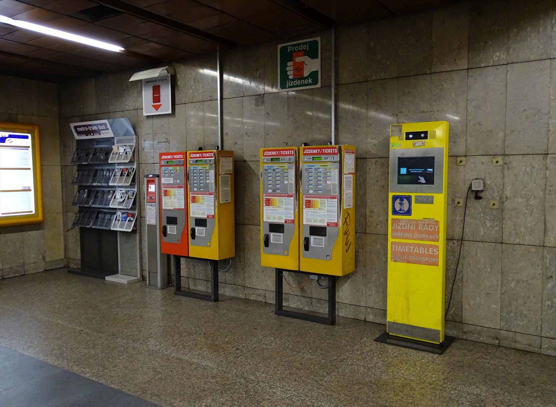 Čtyři jízdenkové automaty a žlutý informační stojan ve stanici Želivského.