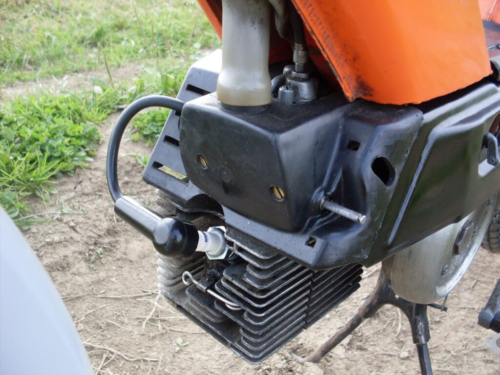 Červený moped Babetta typ 207 s pedály a černým košíkem na zadním nosiči.