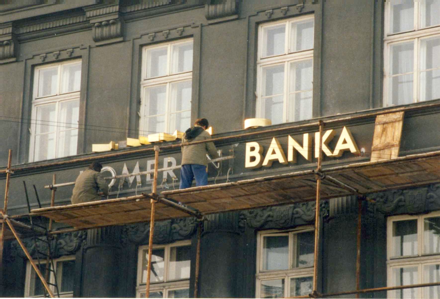 Pobočka banky na náměstí v Novém Jičíně s chodci a automobily v březnu 1992