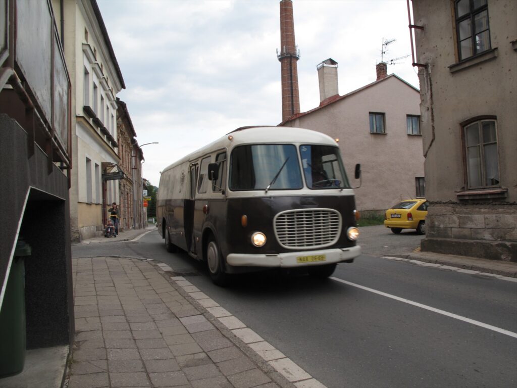 Historický autobus Škoda 706 RTO v červeno-krémovém laku na venkovním prostranství.