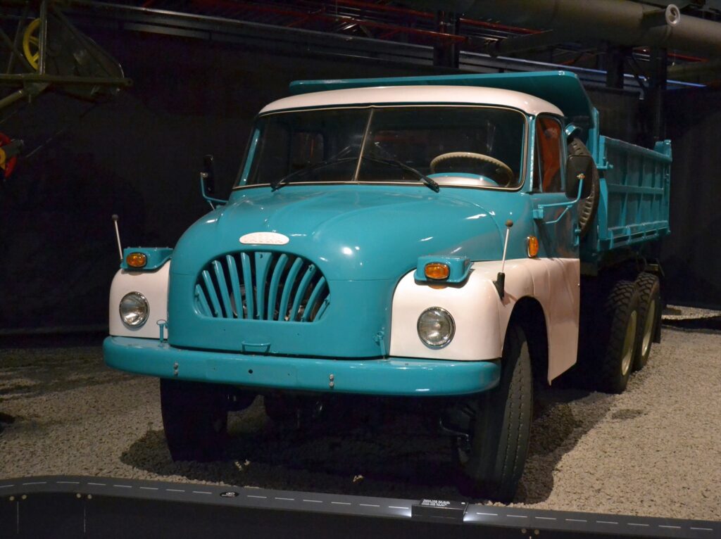 Těžký nákladní automobil Tatra 138 s modrou kabinou a charakteristickou zaoblenou kapotou vystavený v muzeu.
