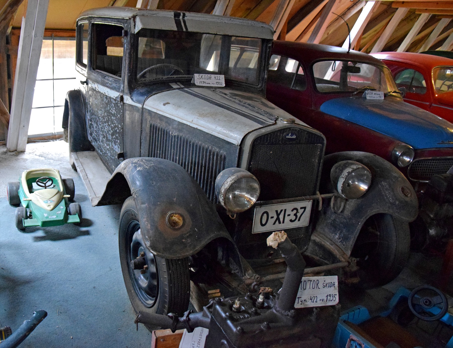 Škoda 422 s vysokou uzavřenou karoserií a volantem vpravo mezi dalšími exponáty muzea.