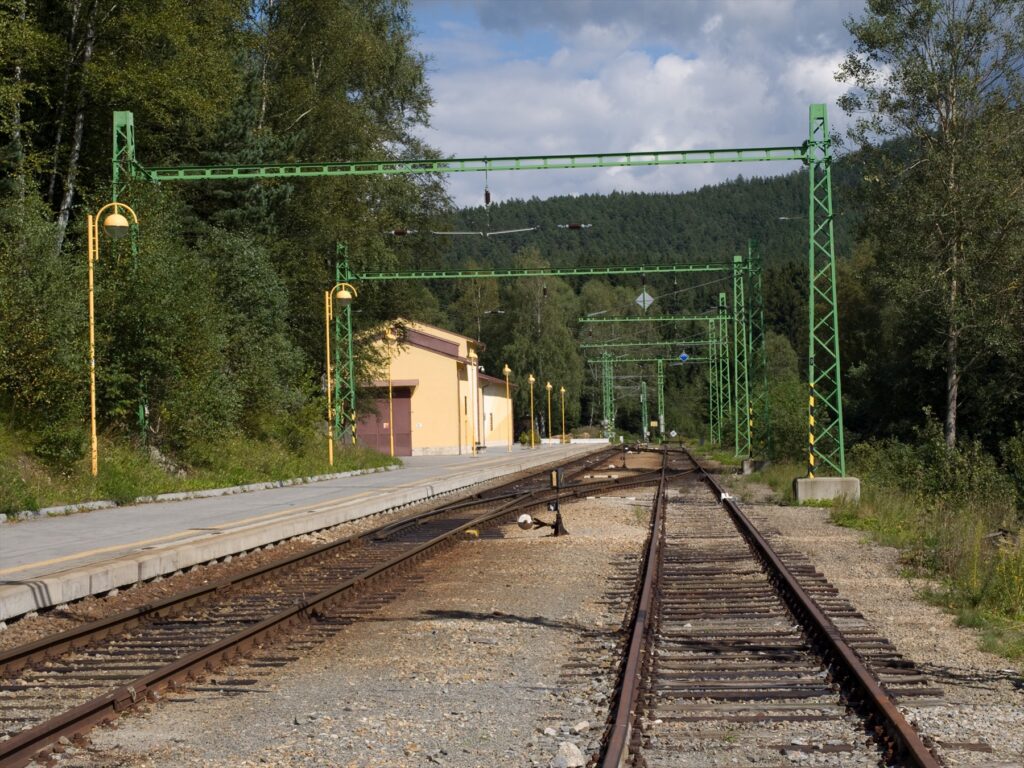 Koleje, trolejové vedení a nástupiště stanice Lipno nad Vltavou.