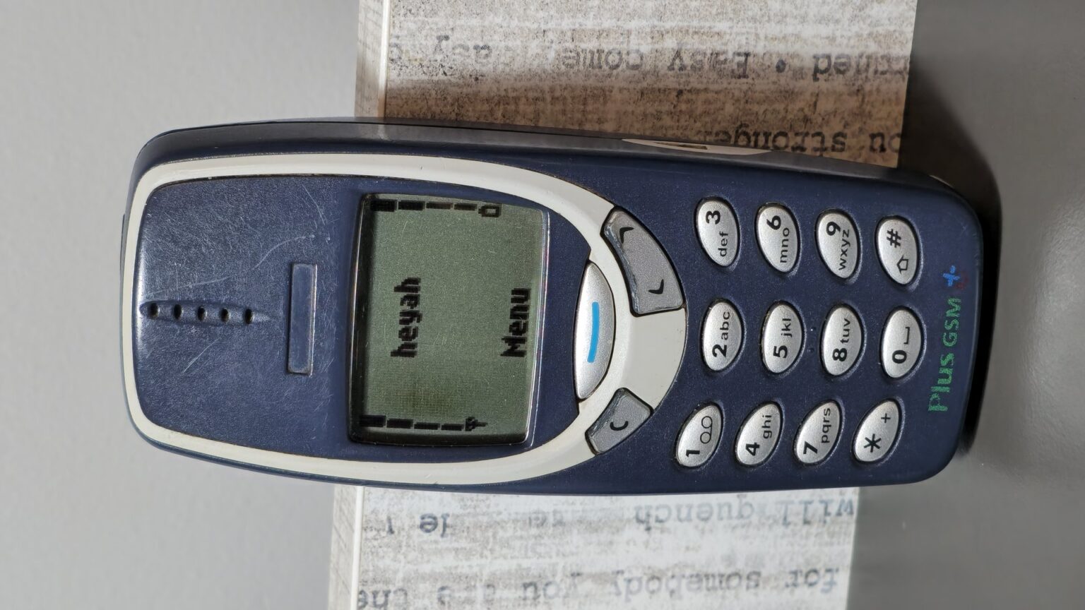 Tlačítkový mobilní telefon Nokia 3310 s numerickou klávesnicí a zeleně podsvíceným displejem