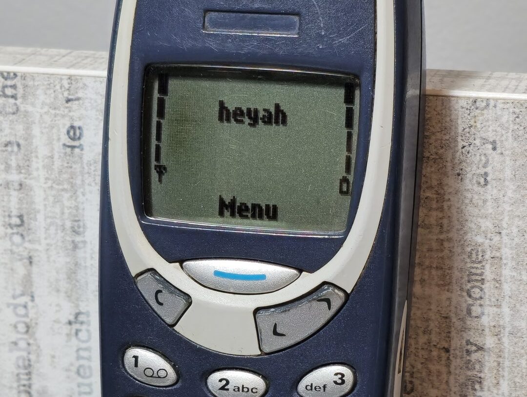 Tlačítkový mobilní telefon Nokia 3310 s numerickou klávesnicí a zeleně podsvíceným displejem