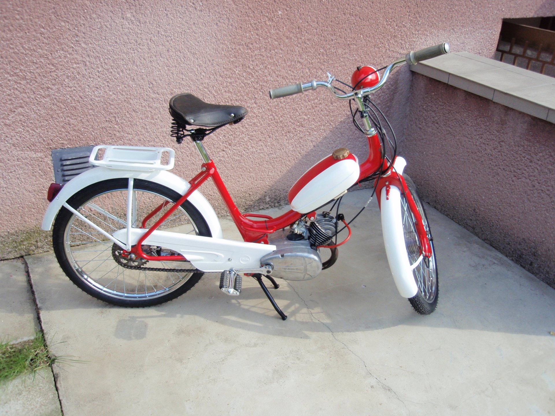 Červený moped Stadion S11 v muzejním stavu s detailem motoru a pedálů