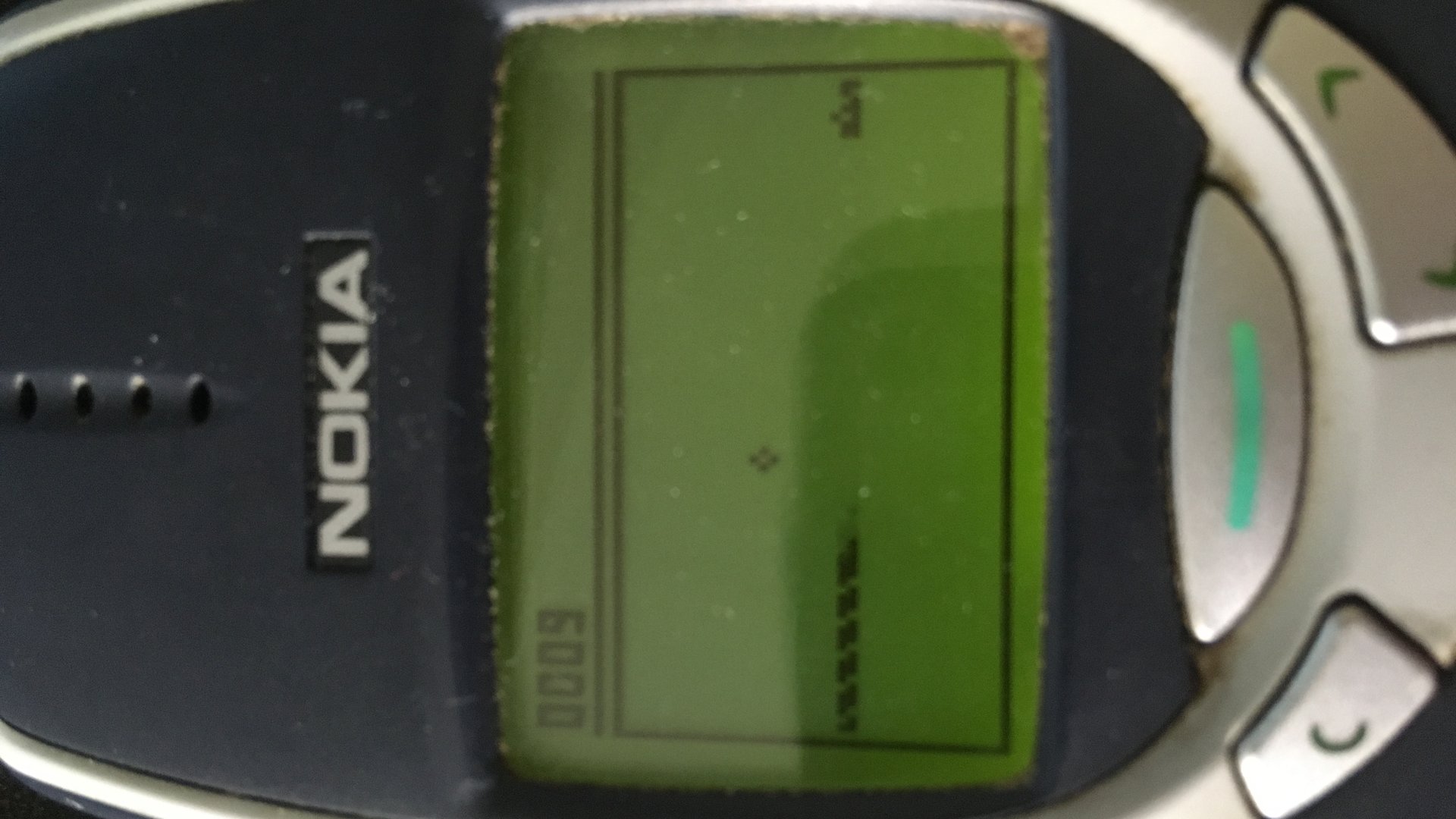 Detailní pohled na monochromatický displej telefonu Nokia 3310 se spuštěnou hrou Snake II