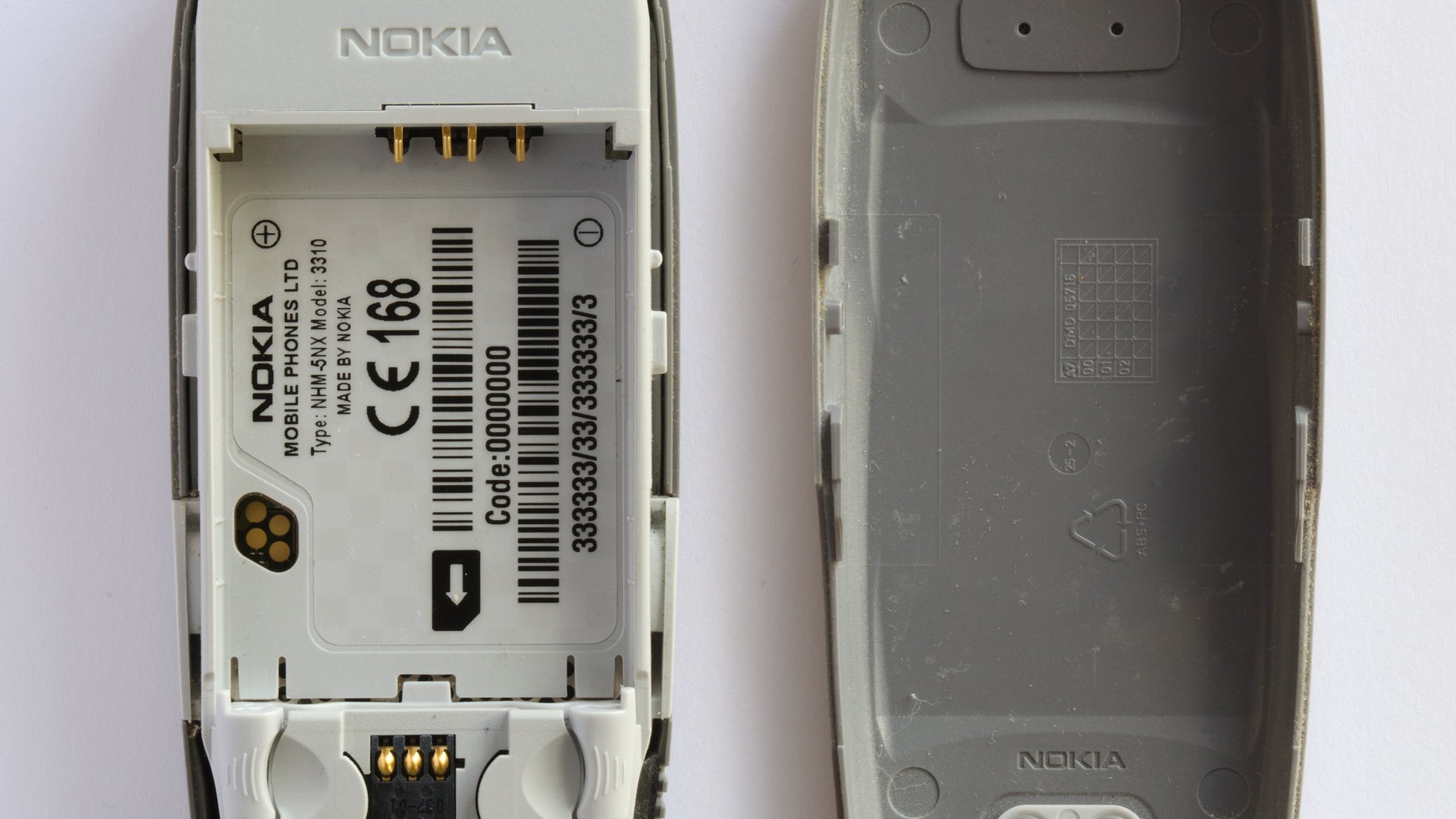 Otevřený telefon Nokia 3310 s prostorem pro baterii a SIM kartu vedle zadního krytu