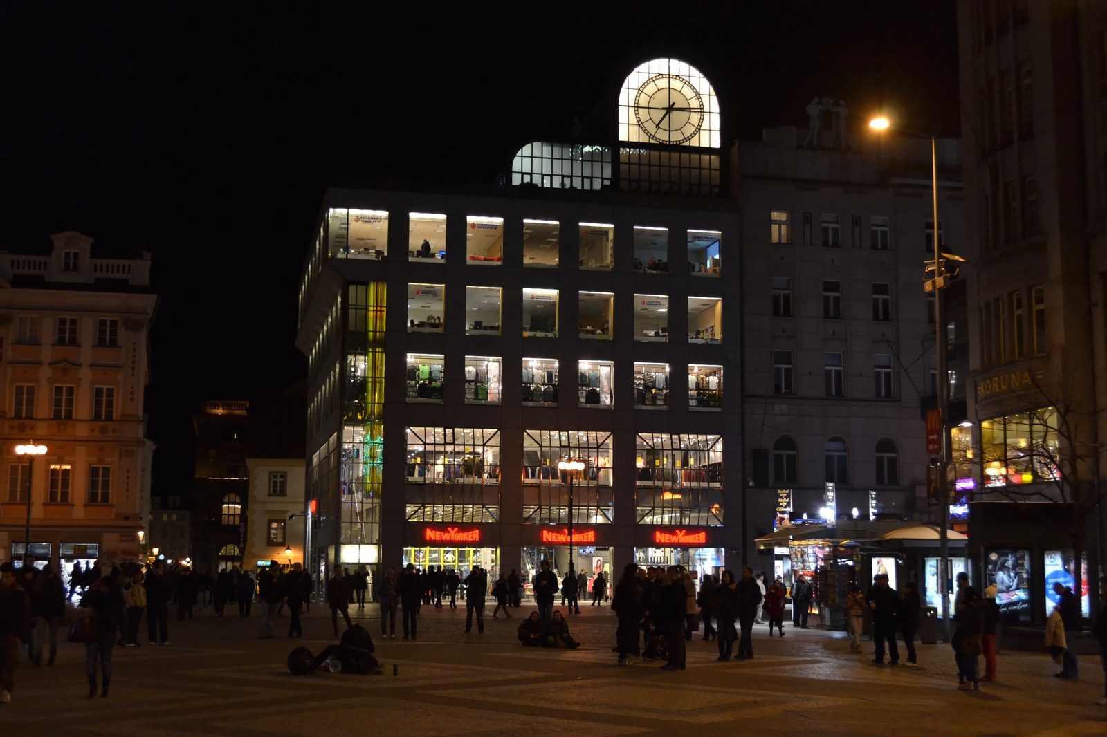 Pohled na fasádu obchodního domu Kotva na náměstí Republiky s typickou architekturou včelích pláství a velkými výlohami.