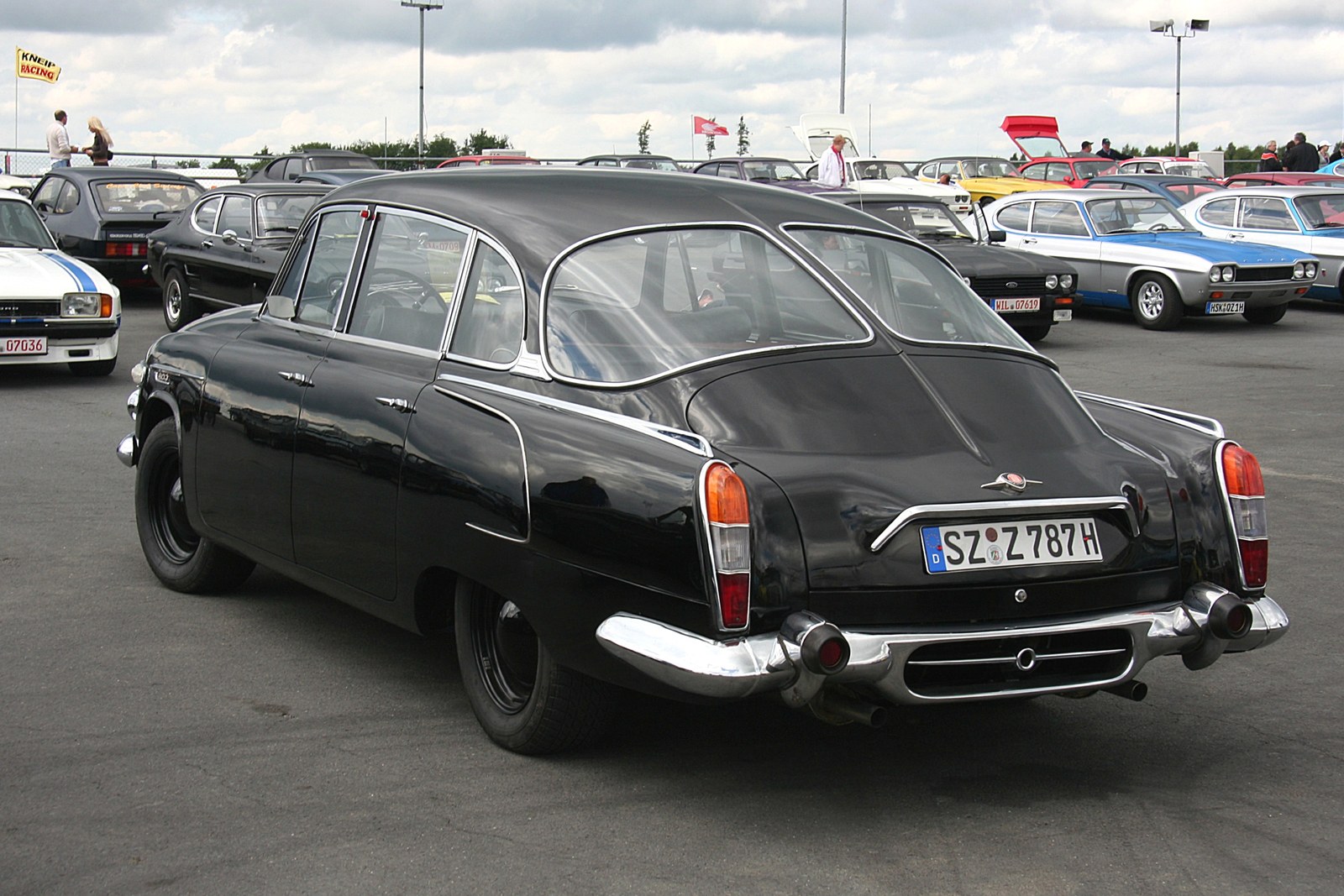 Zadní část černé proudnicové limuzíny Tatra 603 s děleným zadním oknem a bočními sacími otvory chlazení motoru.