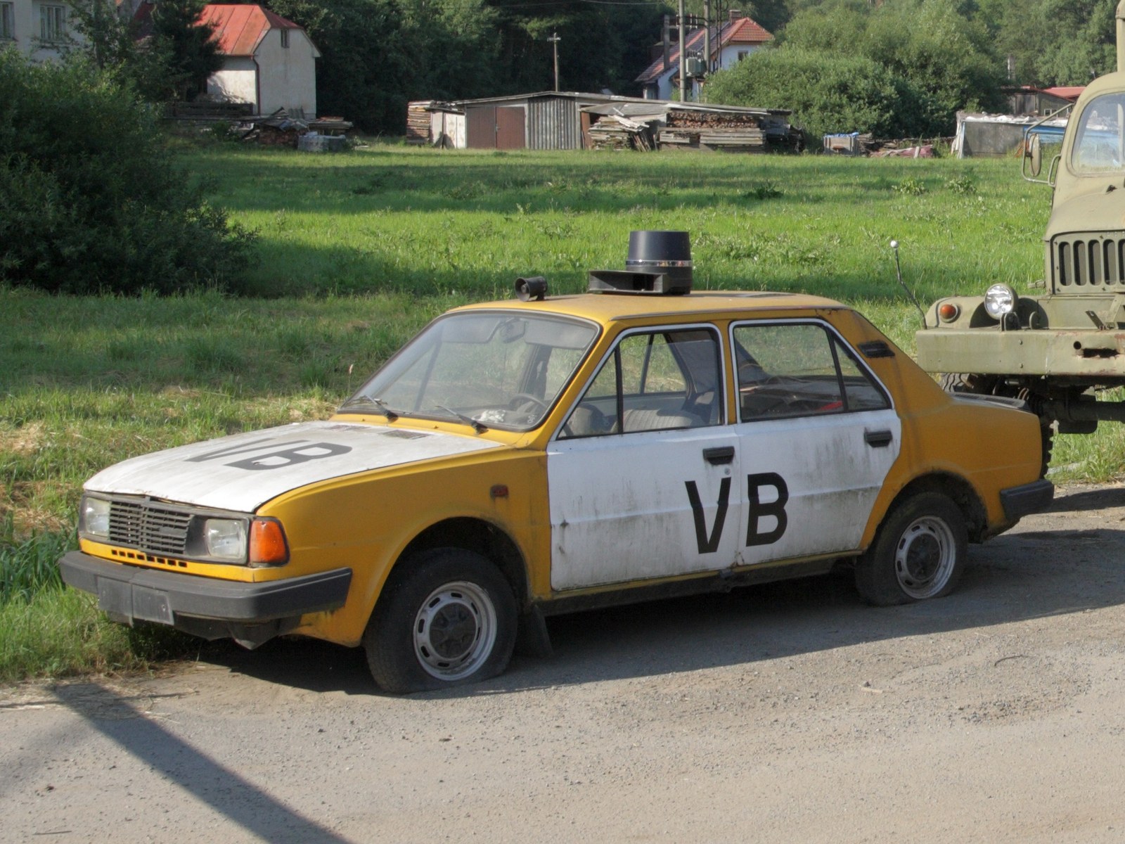 Historický hlídkový automobil Škoda v barvách Veřejné bezpečnosti s modrým majákem na střeše