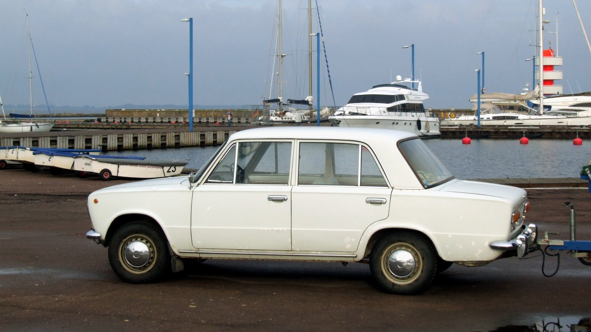 Klasický béžový sedan VAZ 2101 zaparkovaný v městské ulici